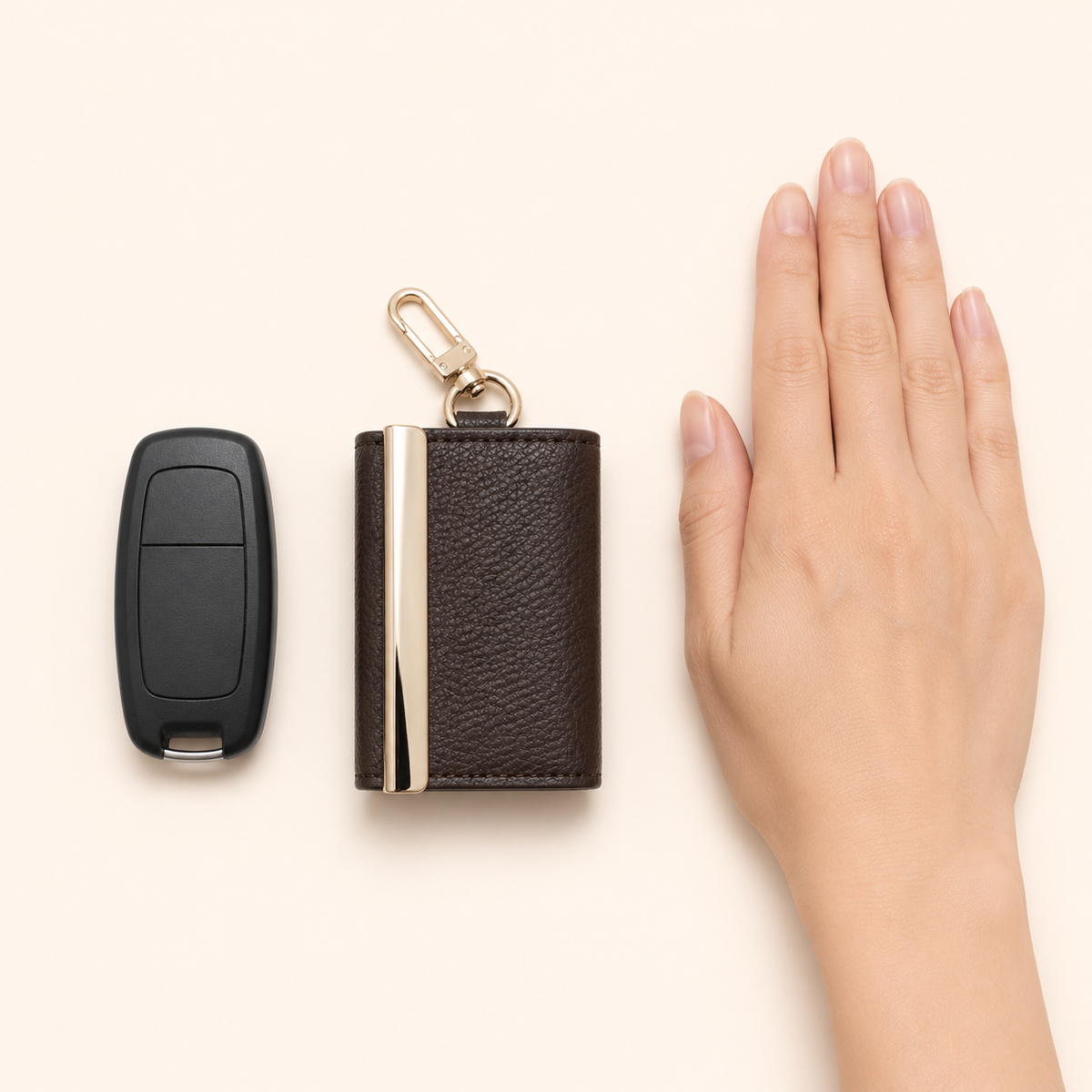 Compact folded tote shown beside a car key and a hand for scale