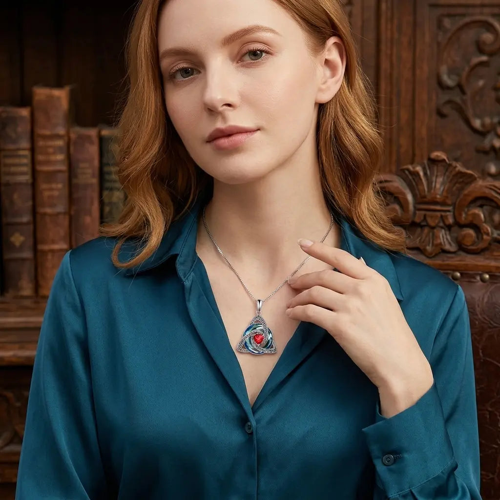 Woman styling the Celtic-inspired birthstone necklace with a blue blouse