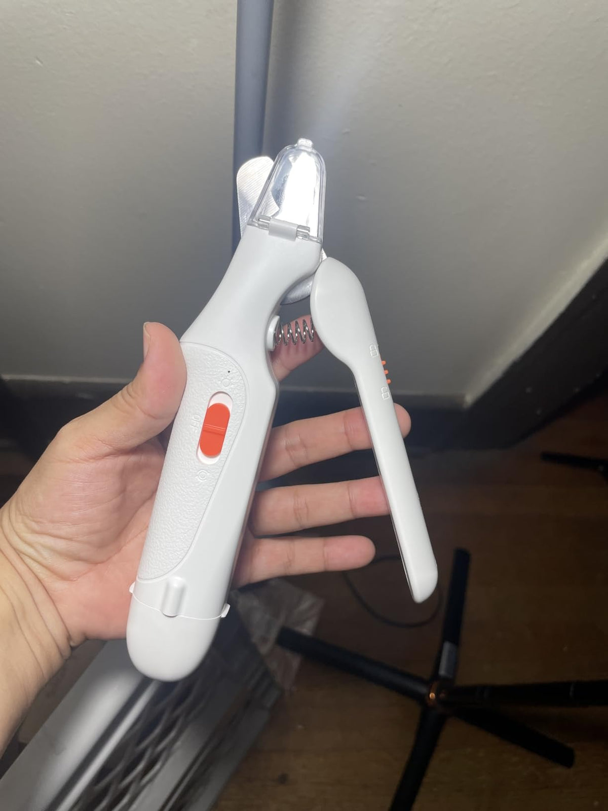White pet nail grooming tool held open in hand