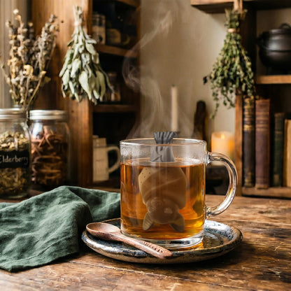 Night Steeper dragon perched on the rim of a glass tea mug with steam rising.