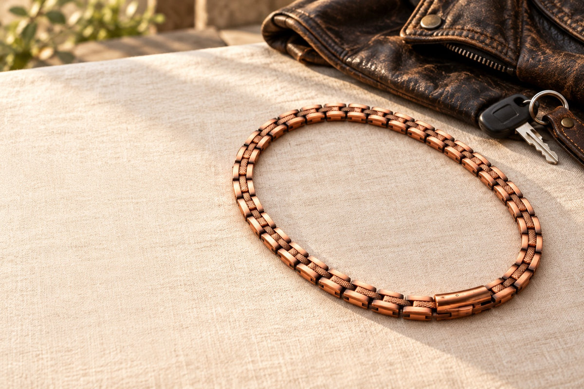 Copper chain laid on cream linen beside a brown leather riding jacket